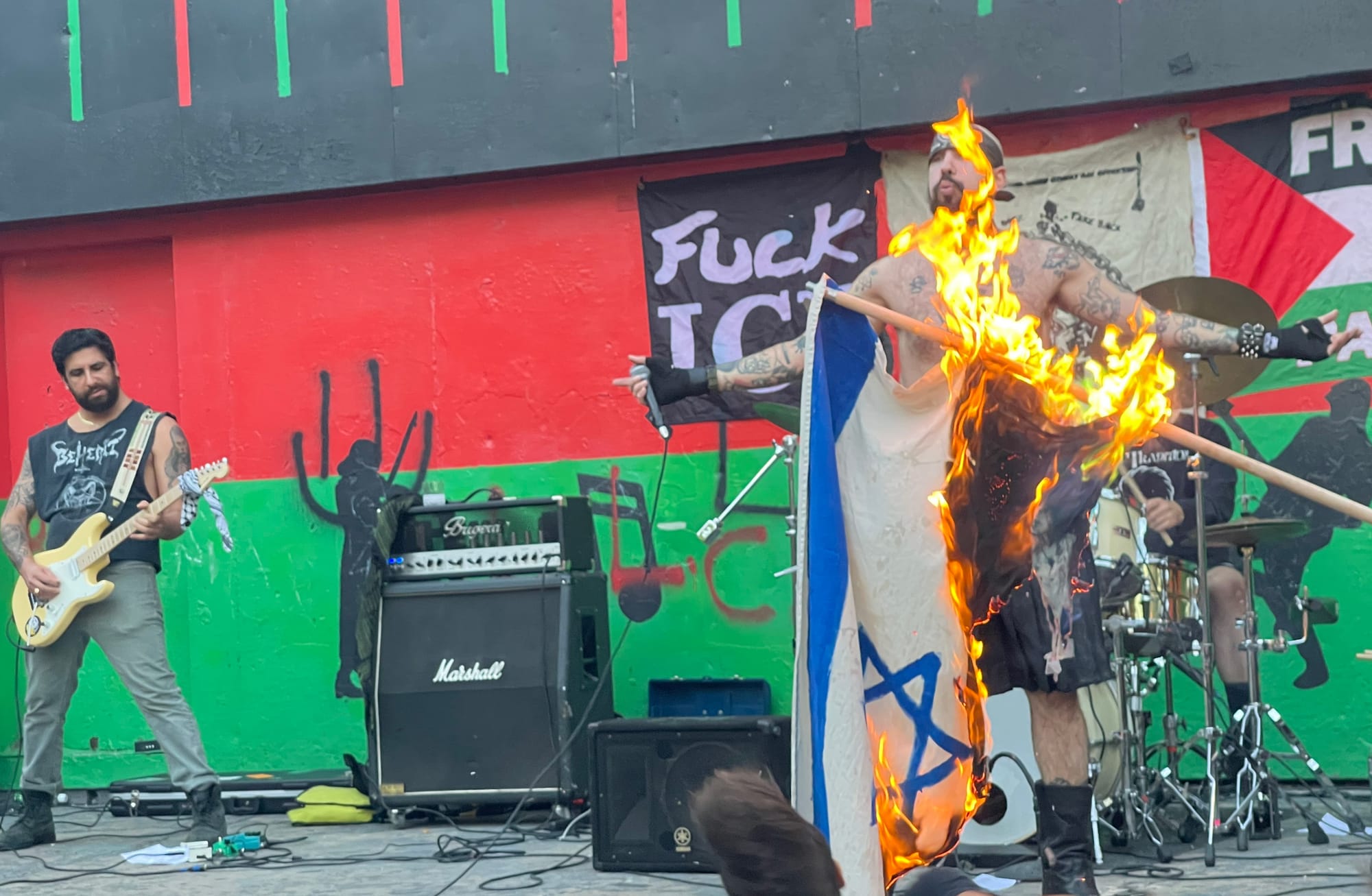 Haram performing at Herbert Von King Park in Bed-Stuy, Brooklyn (September 11, 2025) while someone burns an Israeli flag at the front of the stage; photo by Matthew Ismael Ruiz 